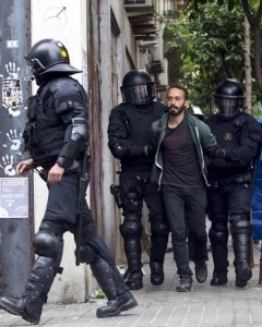 Los Mossos d'Esquadra custodian a uno de los okupas detenidos que han vuelto a entrar en el llamado 'Banc Expropiat' del barrio barcelonés de Gràcia. EFE/Quique García