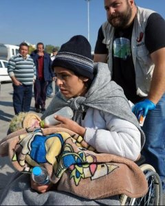 Una mujer da de comer a su hijo mientras es trasladada a un 'hotspot' en Moria, Grecia. - AFP
