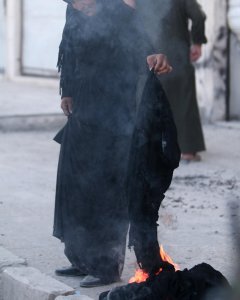 Una mujer quema el niqab tras ser evacuada por las SFD de la ciudad siria de Manbiy, arrebatada al Estados Islámico.- REUTERS/Rodi Said