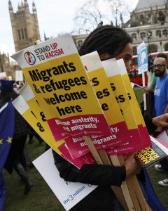 Un manifestante sujeta varias pancartas durante la manifestaciÃ³n en defensa de los inmigrantes en Londres. - REUTERS