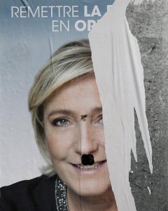 Vista del cartel electoral de la candidata del Frente Nacional (FN), Marine Le Pen a las elecciones presidenciales con una pintada para parecerse a Adolf Hitler en París. EFE/Yoan Valat