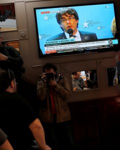 La intervención del expresident Carles Puigdemont en Bruselas, en un televisor en un bar cerca de la Plaza de Sant Jaume, en Barcelona. REUTERS/Jon Nazca
