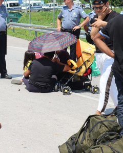 Una familia se protege del sol durante la protesta ante la Policía bosnia. - BÁRBARA BÉCARES
