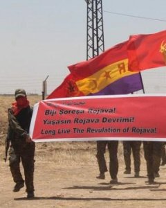 Los miembros de RC que combatieron en Siria pasean una bandera republicana, durante un acto del Batallón de la Libertad de Rojava