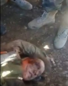 El cuerpo sin vida de un piloto ruso de un avión de guerra derribado por Turquía , rodeado de miembros del grupo rebelde sirio. REUTERS