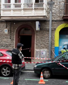 Un ertzaina toma fotografías en la entrada del domicilio del número 14 de la calle Libertad de Vitoria en el que un hombre de 30 años ha arrojado por la ventana a la hija de 17 meses de su pareja, tras una discusión en la que el hombre y la madre de la ni