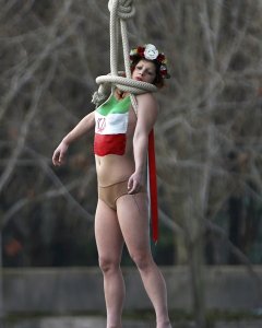Una activista de Femen, congada de un puente de París cerca de la Torre Eiffel, para protestar contra el régimen iraní, con motivo de la visita de su presidente  Hassan Rohani. REUTERS/Charles Platiau