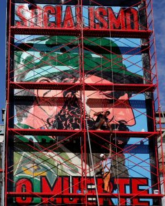 Un hombre pintanto un cartel con el retrato de Fidel Castro con el rótulo 'Socialismo o Muerte', en La Habana. REUTERS/Stringer