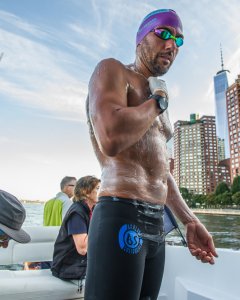 Christian Jongeneel untándose grasa antes de comenzar a nadar alrededor de Manhattan.