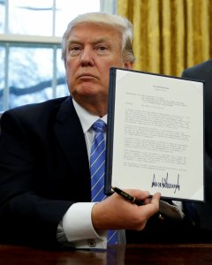 El presidente de EEUU, Donald Trump, muestra el decreto recien firmado para la retirada de Estados Unidos del acuerdo transpacífico. REUTERS/Kevin Lamarque
