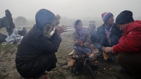 Refugiados encienden una hoguera en el campo de refugiados en la frontera griega y macedonia cerca de Idomeni.- EFE