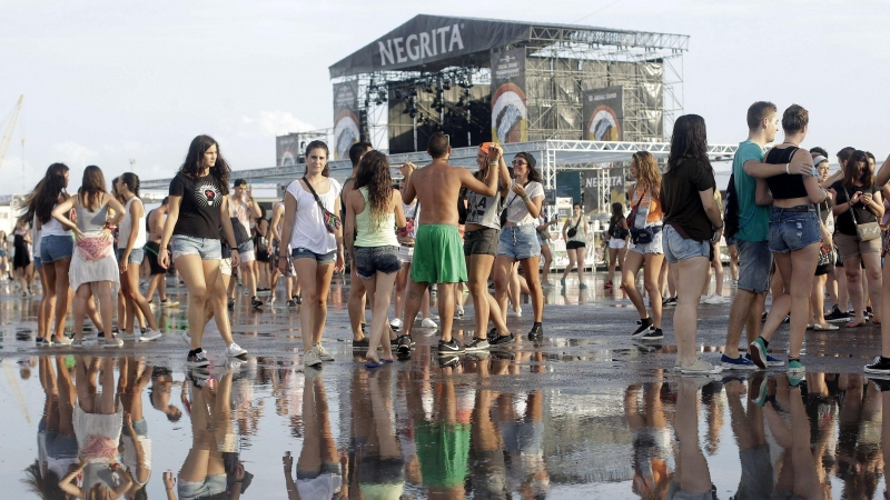 Varias jóvenes tras la tormenta registrada hoy en la primera jornada grande del festival Arenal Sound que se celebra en Burriana. EFE