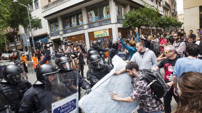 Agentes antidisturbios de los Mossos rodean los accesos del 'Banc Expropiat' de Barcelona tras dispersar a empujones al centenar de personas que se habían concentrado a las puertas de la finca, en apoyo a los okupas. EFE/Quique García