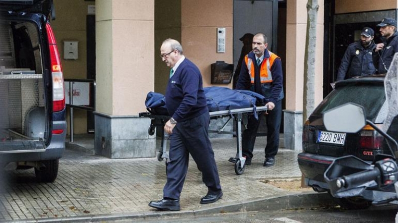 Miembros de los servicios funerarios trasladan los restos mortales de la mujer  fallecida en su piso del barrio de Son Cladera, en Palma. - EFE
