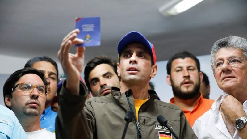 Henrique Capriles sostiene un ejemplar de la Constitución Bolivariana de Venezuela durante un acto de la oposición. | REUTERS