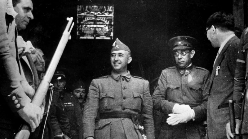 El dictador Francisco Franco con el fajín de generalísimo, acompañado por el general Mola.
