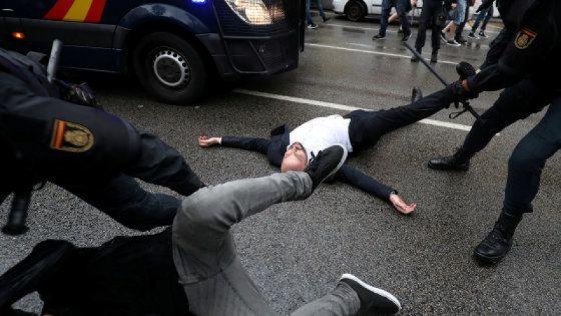 Agentes de la Policía Nacional arrastran a varios de los concentrados en un colegio electoral de Barcelona durante la jornada del referéndum del 1 de octubre de 2017. REUTERS/Susana Vera