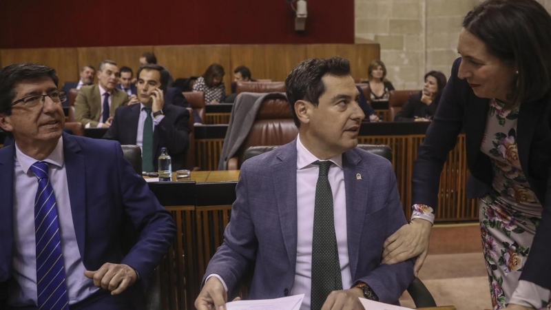 Juanma Moreno, junto a Juan Marín, atiende a Loles López, hoy en el Parlamento. Europa Press