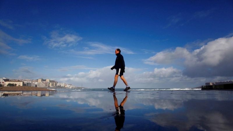 Un hombre camina por el paseo marítimo de A Coruña, donde este viernes se espera algún intervalo nuboso con la posibilidad de precipitaciones débiles./ Cabalar (EFE)