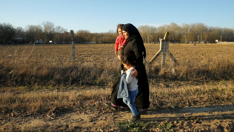 28/02/2020 - Una mujer migrante camina con niños al cruce fronterizo Pazarkule de Turquía. REUTERS / Huseyin Aldemir
