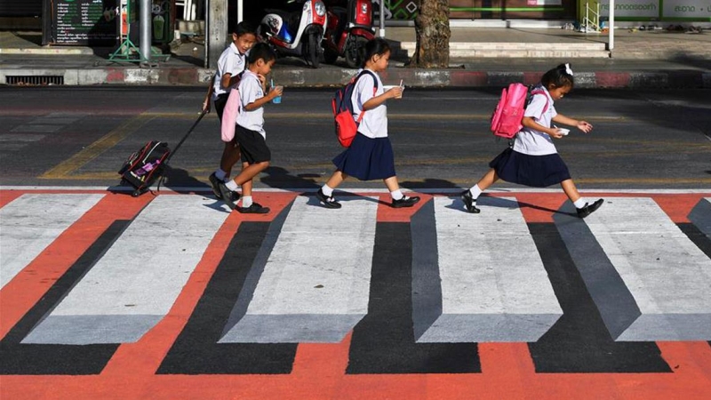 Niños cruzan un paso de cebra en 3D en Bangkok. / REUTERS