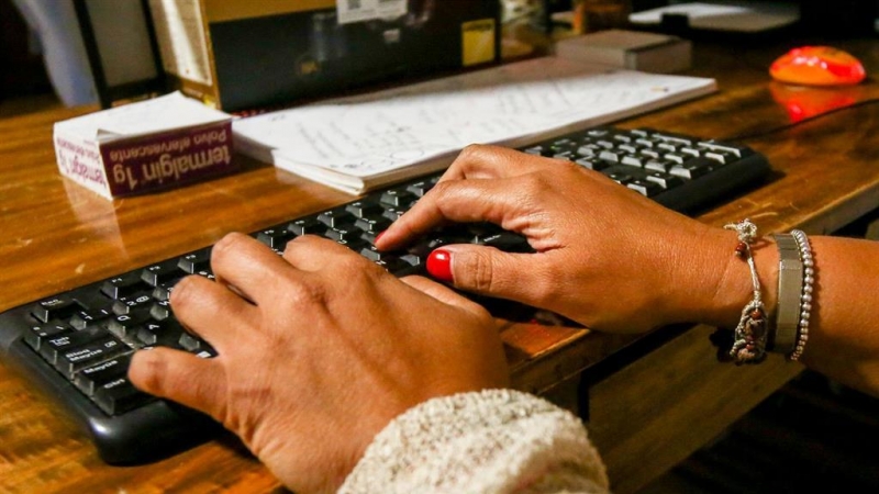Unas manos de mujer escriben en el teclado de un ordenador, sobre una mesa de madera. - Ricardo Rubio - Europa Press - Archivo