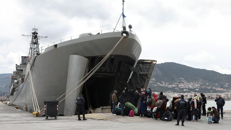 Un grupo de refugiados embarca en el buque militar enviado por el Gobierno griego a la isla de Lesbos.- REUTERS