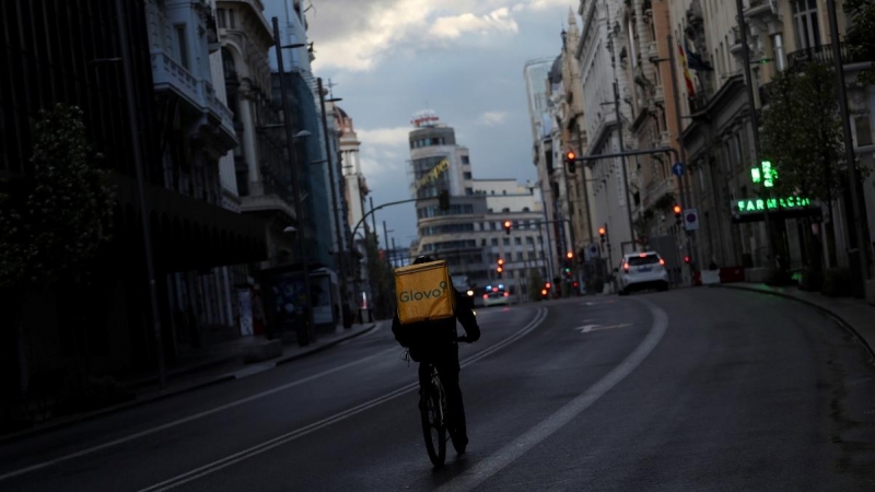 Un repartidor circula en bicicleta por la Gran Vía de Madrid, que permanece prácticamente sin coches debido a la crisis del coronavirus. Reuters/Susana Vera