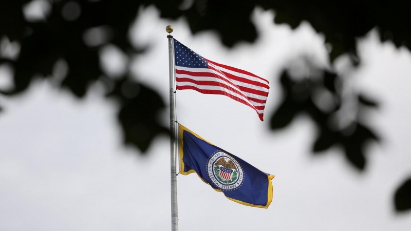 La bandera de EEUU sobre la enseña de la Reserva Federal (Fed) en lo alto de la sede del banco central estadounidense en Washington. REUTERS/Chris Wattie