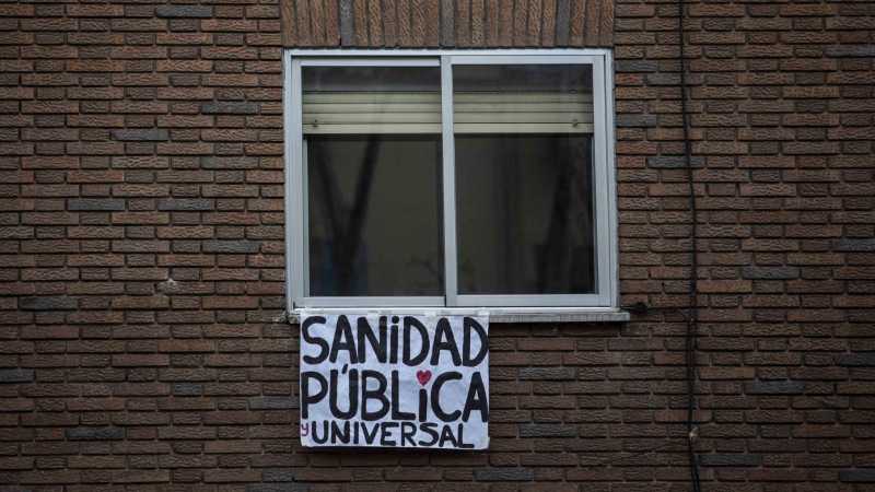 Un cartel en el que pone 'Sanidad pública y universal' cuelga de una ventana durante la cuarentena / JAIRO VARGAS