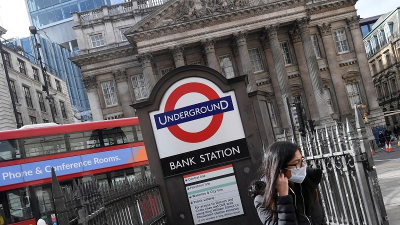 Una noven con mascarilla sale de la boca de metro junto a la sede del Banco de Inglaterrra, en la City de Londres. REUTERS/Toby Melville