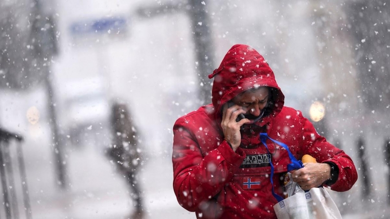 Un hombre camina por una calle de Reinosa, este lunes en la comunidad cántabra donde la Agencia Estatal de Meteorología mantiene activada la alerta por nevadas. EFE/Pedro Puente Hoyos