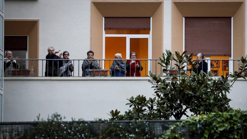 Un grupo de jubilados aplaude aplaude desde un balcón para agradecer el trabajo de los sanitarios que luchan contra la pandemia de coronavirus, en la decimoquinta jornada de estado de alarma. EFE/Javier Etxezarreta