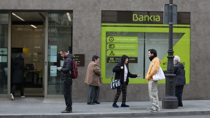 Varias personas esperan en una cola respectando la distancia de seguridad para entrar en una sucursal de Bankia de Madrid. E.P./Marta Fernández Jara