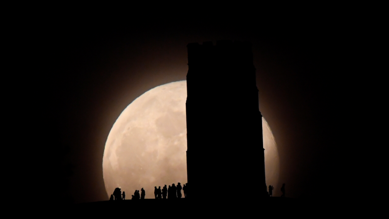 Gente viendo la superluna desde la Torre de San Miguel, Glastonbury, Gran Bretaña. REUTERS / Toby Melville
