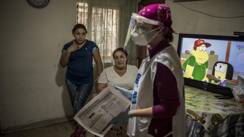Loredana, de 46 años, y su hija de 13 escuchan las instrucciones sobre cómo evitar la infección por coronavirus por un médico voluntario de la ONG Médicos del Mundo en su casa de Granada. Originarios de Rumanía, viven en un piso ocupado, junto con otros 1