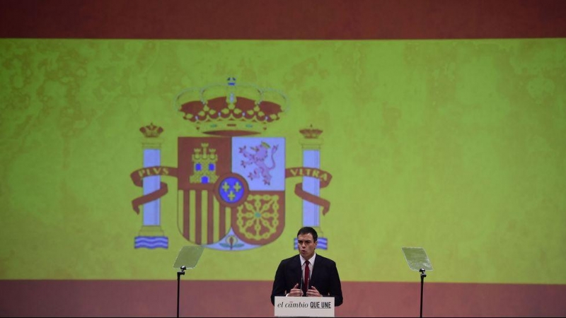 Pedro Sánchez, junto a una gran bandera rojigualda. EFE
