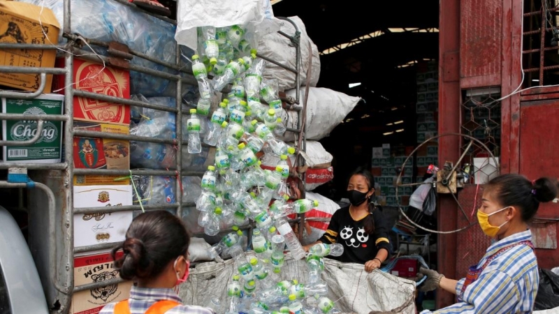 Mujeres recogen botellas de plástico traídas por un camión a una planta de reciclaje durante el brote de la enfermedad por coronavirus en Bangkok, Tailandia. REUTERS / Jorge Silva