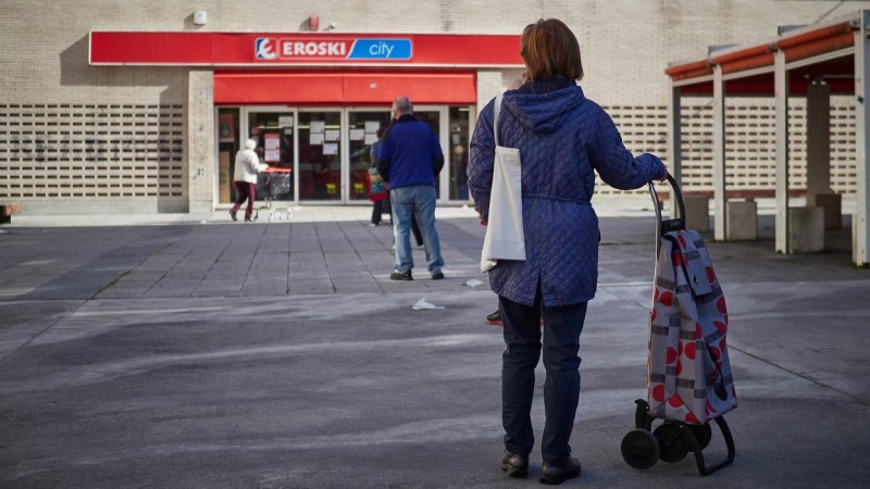 Varias personas guardan cola manteniendo la distancia social para hacer la compra en un supermercado de Eroski en Pamplona. E.P./Eduardo Sanz