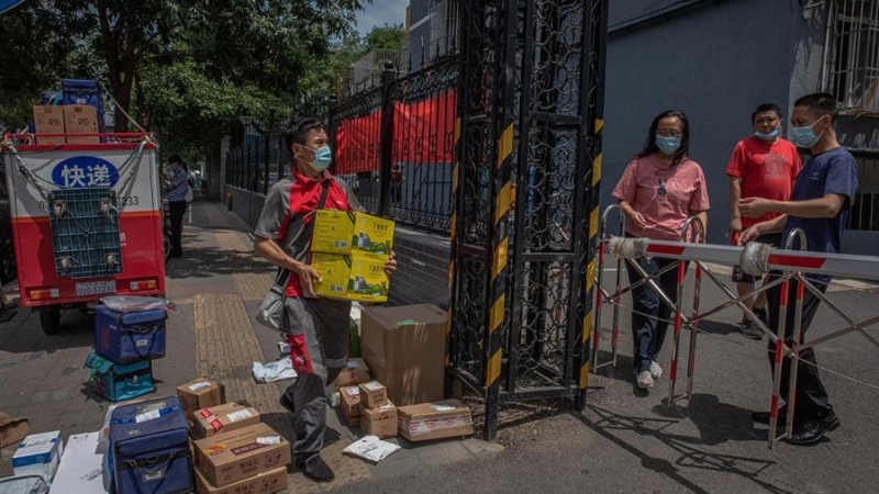 Un repartidor entrega paquetes para los residentes en un complejo residencial cerrado cerca del mercado de Yuquandong, en el distrito de Haidian, Pekín, China. EFE/EPA/ROMAN PILIPEY