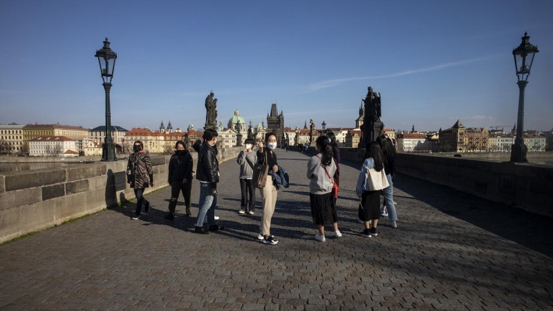 Turistas japoneses con mascarilla en el Puerte de Carlos, de Praga, en las primeras semanas de la pandemia por coronavirus. AFP/Michal Cizek