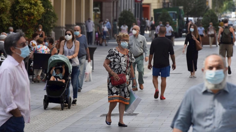 Varias personas con mascarilla caminan por las calles de Huesca . EFE/ Javier Blasco