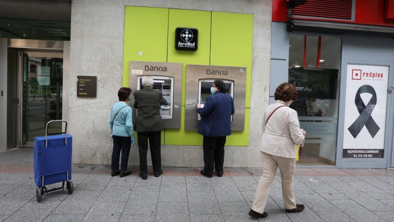 Personas mayores sacan dinero en un cajero de Bankia durante el estado de alarma por la crisis del coronavirus. E.P./Marta Fernández