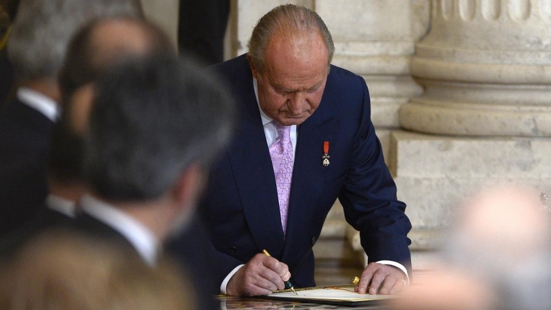 Juan Carlos I firma su abdicación, en una ceremonia en la Sala de Columnas del Palacio Real de Madrid, el 18 de junio de 2014. AFP/GERARD JULIEN