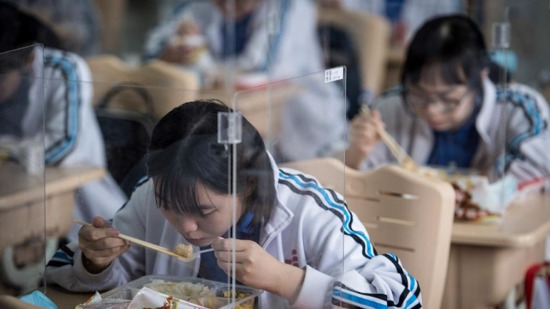 Alumnos de la escuela secundaria almorzando durante su último día en la escuela secundaria antes del Examen de ingreso a la universidad nacional (NCEE), el 7 de julio de 2020. / STR / AFP