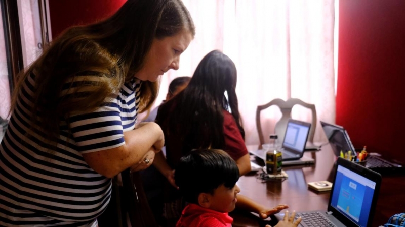Una madre ayuda a sus dos hijos menores con el colegio online mientras su padre ayuda a su hija mayor en el condado de Broward, Florida, EE.UU. Alejandra Cardona / Reuters / Archivo