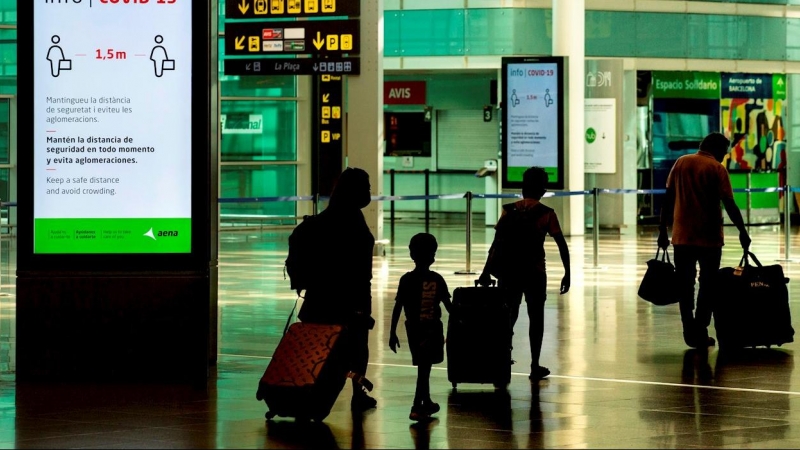 Viajeros con máscaras sanitarias caminan por la Terminal 1 del aeropuerto Josep Tarradelles - El Prat, en Barcelona. EFE/ Enric Fontcuberta