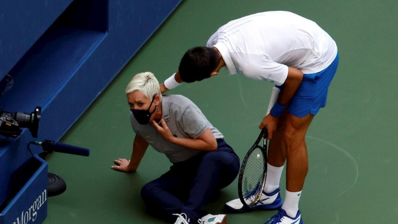 Novak Djokovic de Serbia intenta ayudar a una jueza de línea después de golpearla con una pelota en la garganta durante su partido contra Pablo Carreño en el US Open Tennis. EFE / EPA / JASON SZENES