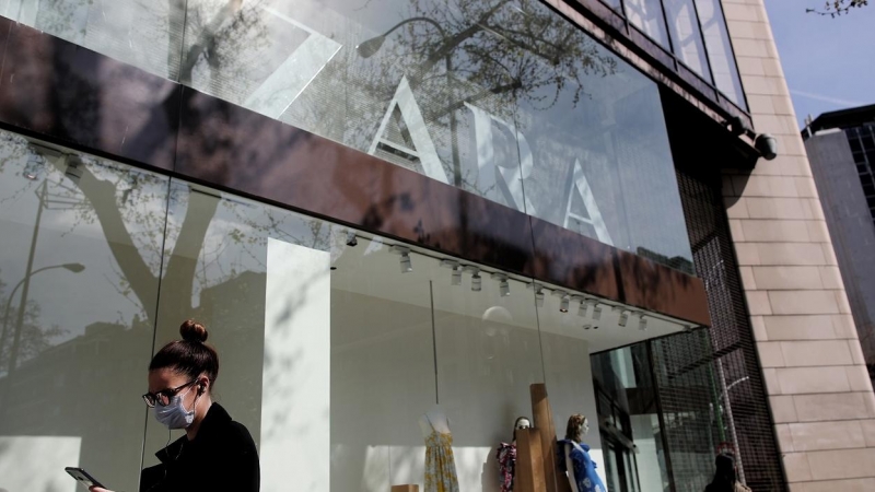 Una mujer con mascarilla pasa junto al escaparate de la tienda Zara, la principal enseña de Inditex, en Madrid. E.P./Eduardo Parra