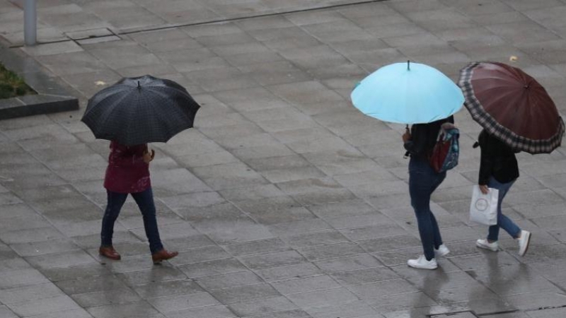 Escolares se protegen de la lluvia con paraguas en Bilbao / EFE